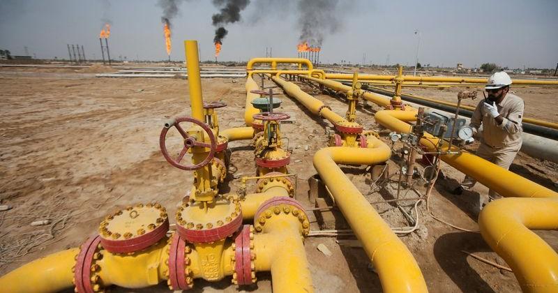 FILE PHOTO: A worker checks an oil pipeline at Nahr Bin Umar oil field, north of Basra