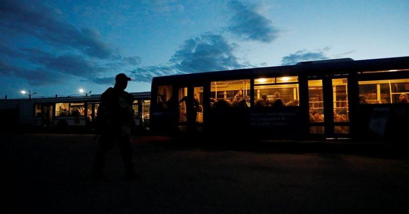 Buses carrying service members of Ukrainian forces who have surrendered after weeks holed up at Azovstal steel works arrive in Olenivka