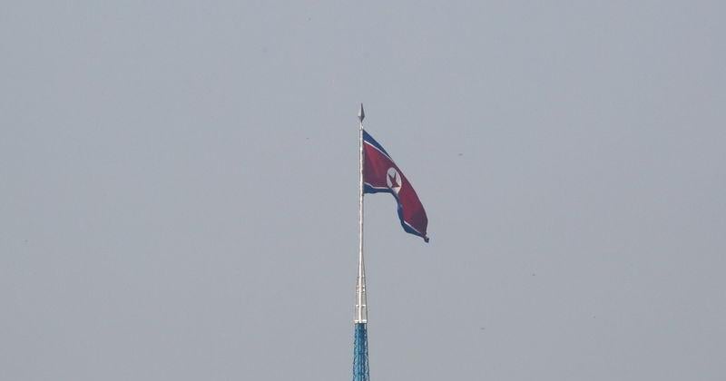 A North Korean flag flutters on top of a tower at North Korea's propaganda village of Gijungdong, as seen from Paju