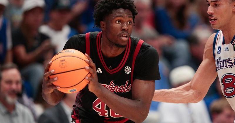 Louisville Cardinals forward Flory Bidunga (40) looks for an open pass against Kansas Jayhawks forward Keanu Dawes (8) during