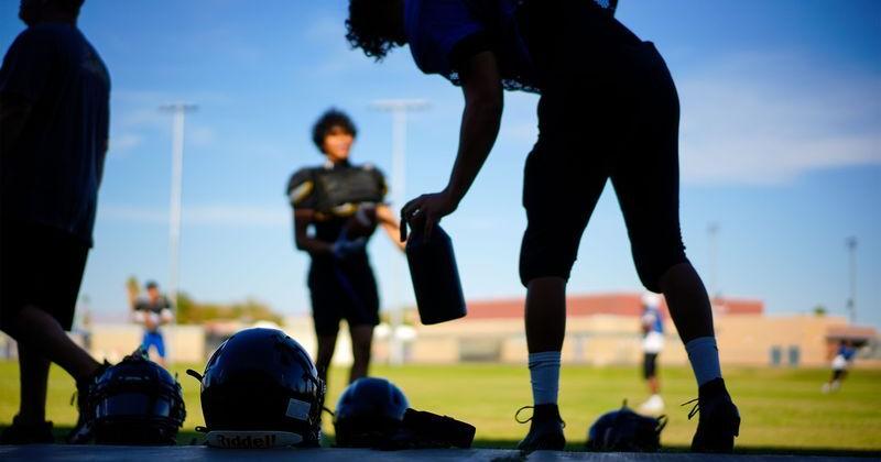 High school football players take a water break during triple-digit temperatures at practice in Cathedral City, California, on Aug. 19, 2025.