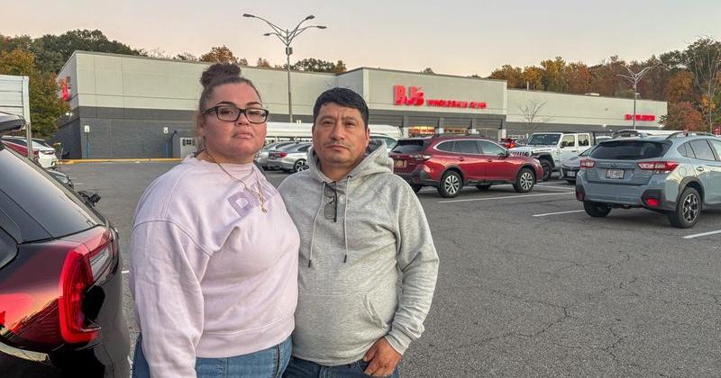 Joanice Patino and her husband Jose Patino stand next to their car in the parking lot of a BJ's Wholesale Club in Yorktown Heights