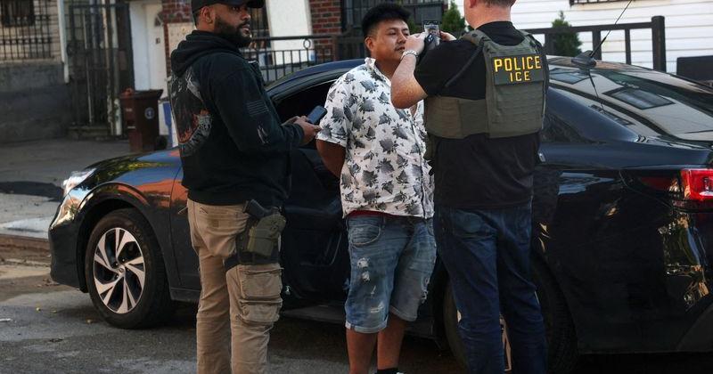 U.S. Immigration and Customs Enforcement (ICE) agents take a photograph of a man as part of a Targeted Enforcement Operation in the Corona neighborhood of the Queens borough of New York City