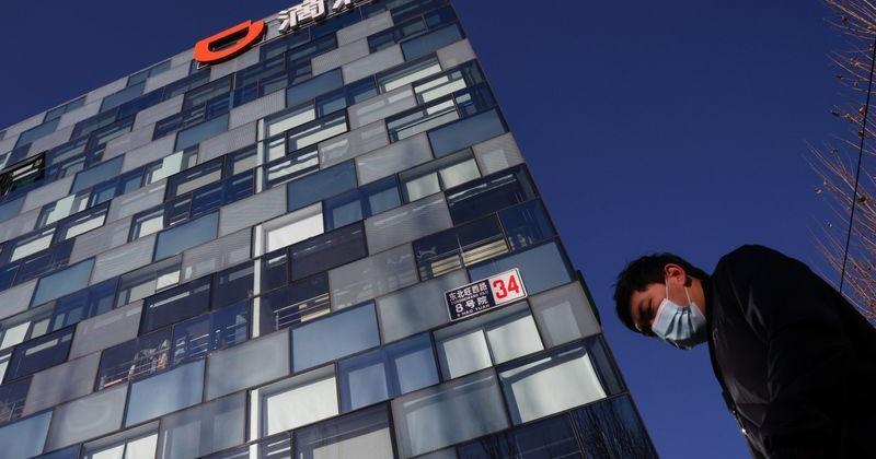 A man walks past the headquarters of the Chinese ride-hailing service Didi in Beijing