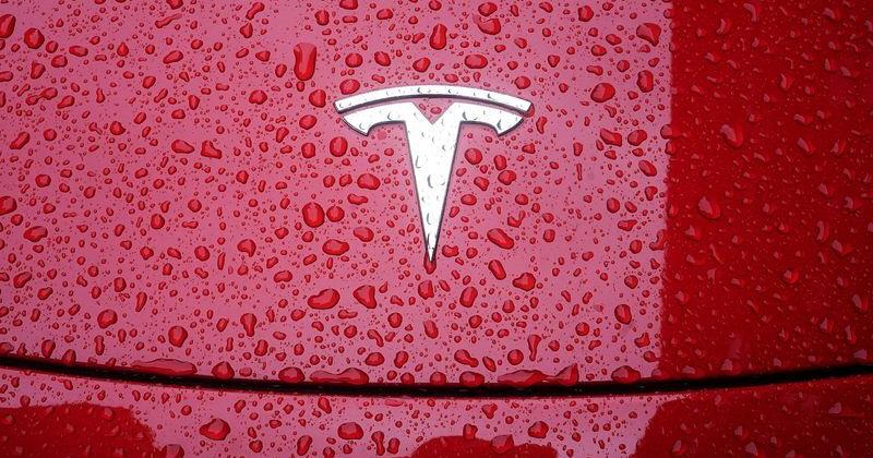 FILE PHOTO: A Tesla logo is pictured on a car in the rain in New York City