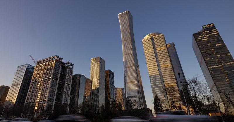 Cars drive along the road next to skyscrapers of the Central Business District in Beijing