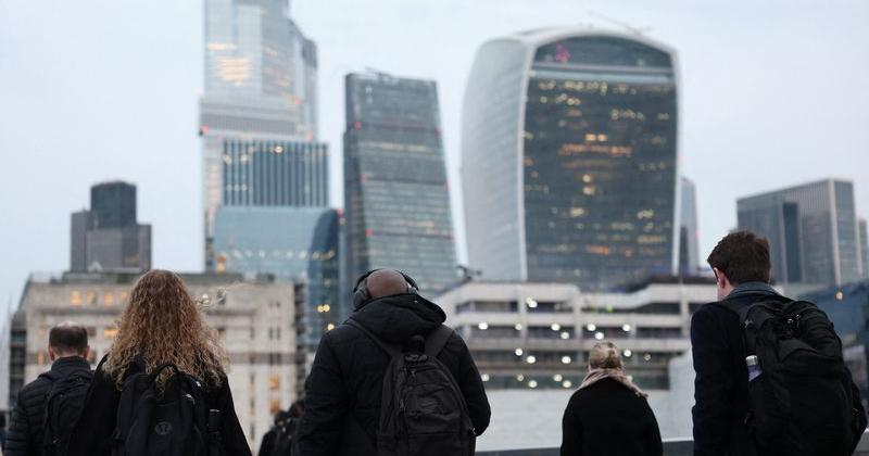 Workers cross London Bridge during the morning rush-hour in London