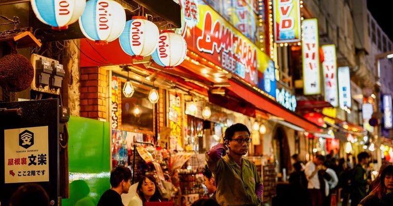 People enjoy drinks and food at izakaya pub restaurants at the Ameyoko shopping district, in Tokyo