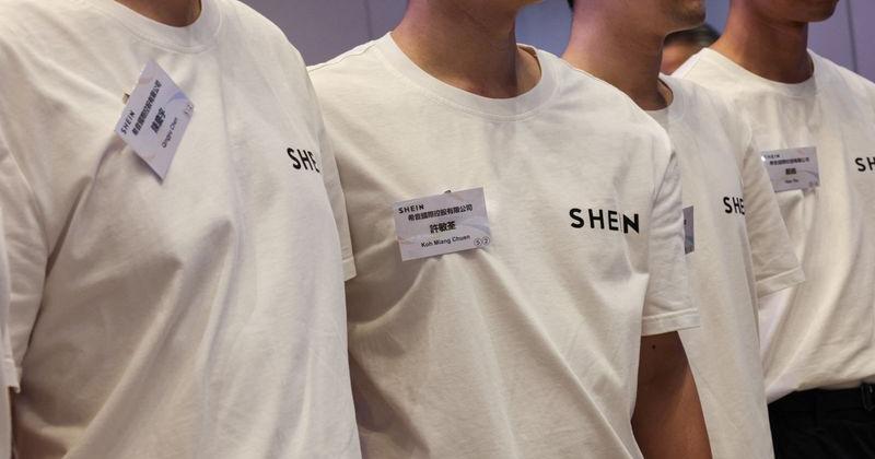Staff members pose for photos during the listing ceremony for online retailer Shein at the Hong Kong Stock Exchange in Hong Kong