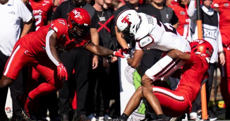 Cincinnati Bearcats edge rusher Brian Simms III (17) and Cincinnati Bearcats cornerback Kenny Worthy (8) tackle Texas Tech Red Raiders wide receiver Kenny Johnson (2) in the first quarter of the Big 12 game between Cincinnati Bearcats and Texas Tech at Nippert Stadium in Cincinnati on Saturday, October 24, 2026.