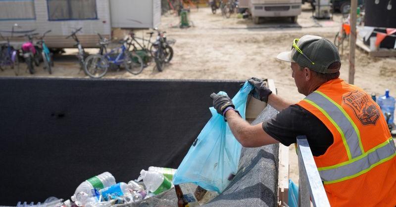 Workers at Burning Man 2026 collect trash and recycling from attendees who used the 