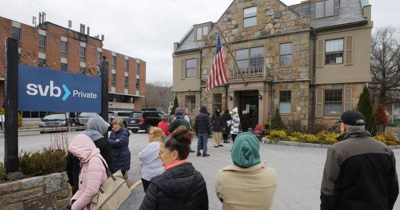 Customers wait in line outside a branch of Silicon Valley Bank in Wellesley, MA