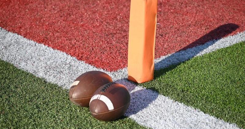 Footballs sit on the field at East China Stadium in East China Township on Friday, Sept. 12, 2025.