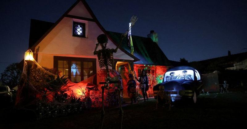 FILE PHOTO: Families go trick-or-treat by a decorated house on Halloween night in Pasadena