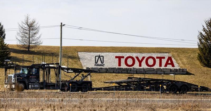 A car carrier truck drives past a sign at the Toyota Motor Manufacturing plant in Cambridge, Ontario
