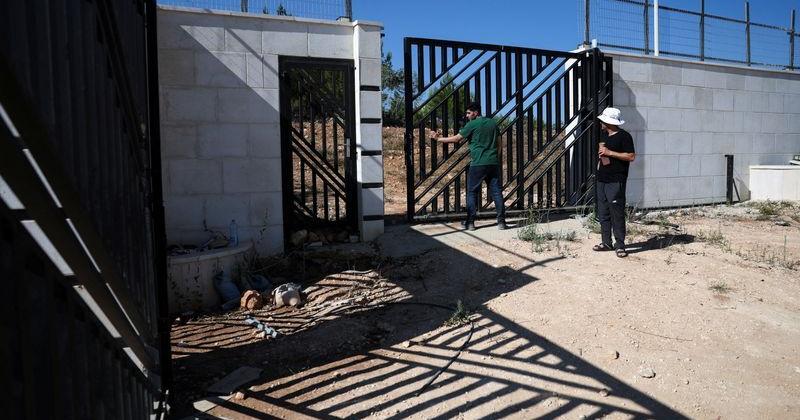 Ahmed Ridi closes the gate of his uncle Loui Ridi's house, which has been encircled by militant settlers for the past week, in Qusra