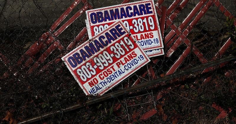 Signs for former Obamacare health insurance plans lay next to a fence in Columbia, South Carolina