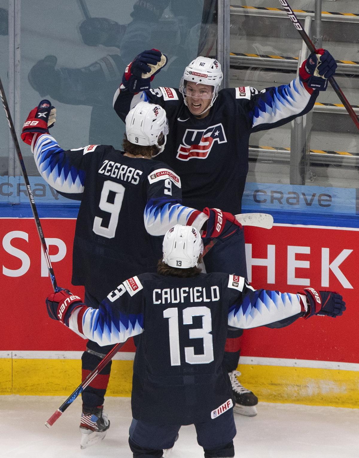 United States' Cole Caufield (13), Matthew Boldy (12) and Matthew Beniers  (10) celebrate a goal against Austria during during the second period of an  IIHF World Junior Hockey Championship game Saturday, Dec.