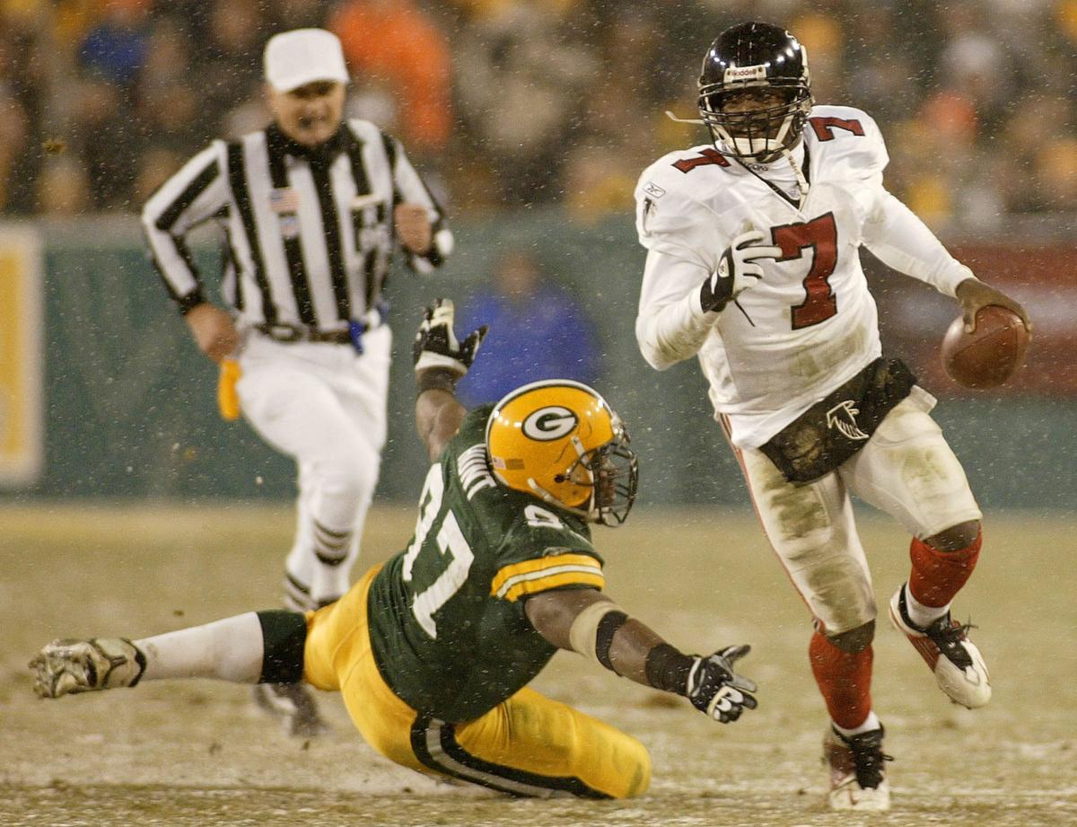 Michael Vick evades a tackle as he led the Falcons to an opponent's first playoff victory at Lambeau Field.