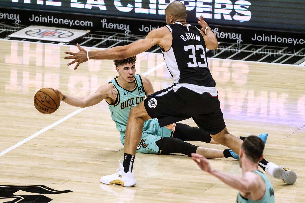 The Charlotte Hornets' LaMelo Ball passes the ball to teammate Gordon Hayward, bottom right, as the Los Angeles Clippers' Nicolas Batum defends during first-half action at Staples Center in Los Angeles on Saturday, March 20, 2021.