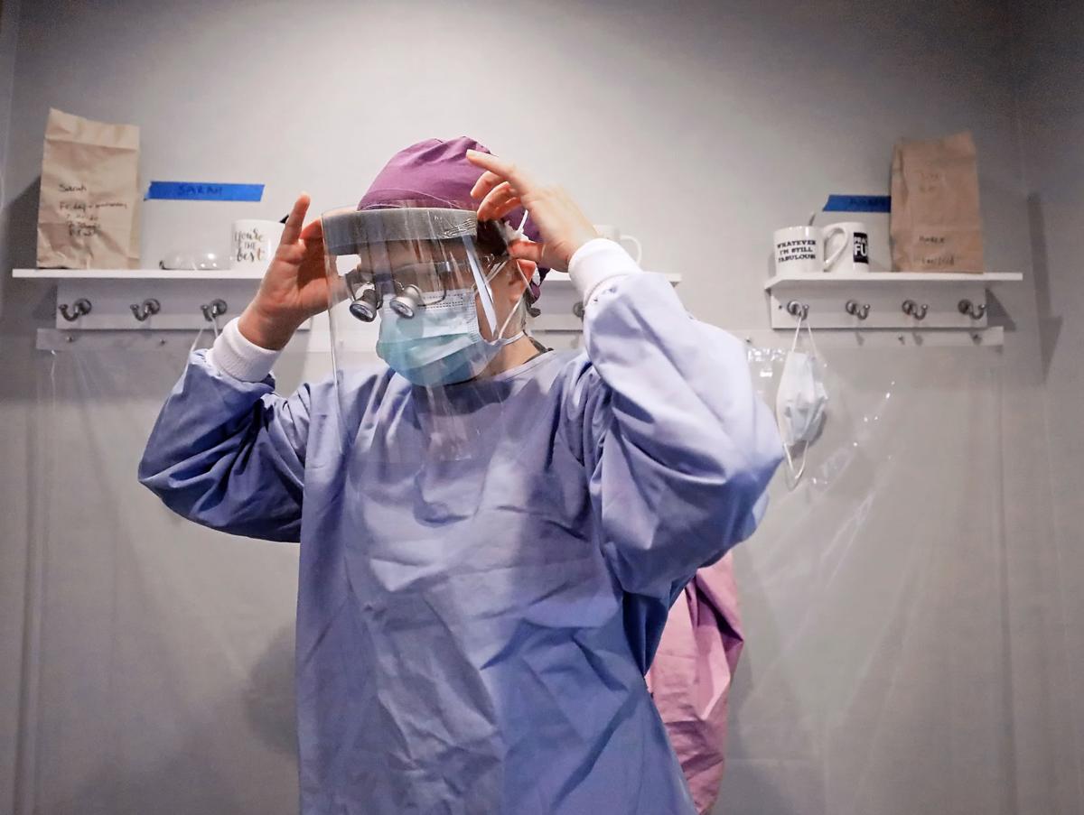 Hygienist donning PPE