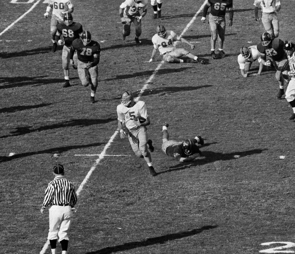 Paul Hornung (5), Green Bay Packers halfback, finds running room for a  six-yard gain against the Chicago Bears in third quarter in Chicago, Dec.  4, 1960. Packers guard Fred Thurston (36) blocks