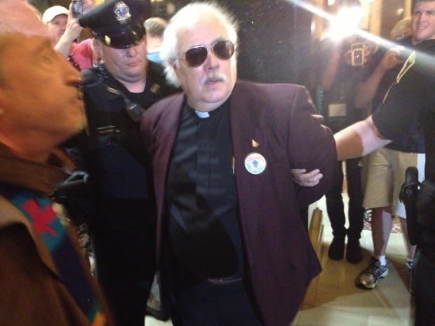 The Rev. Carter Dary is arrested Friday at the Solidarity Singalong