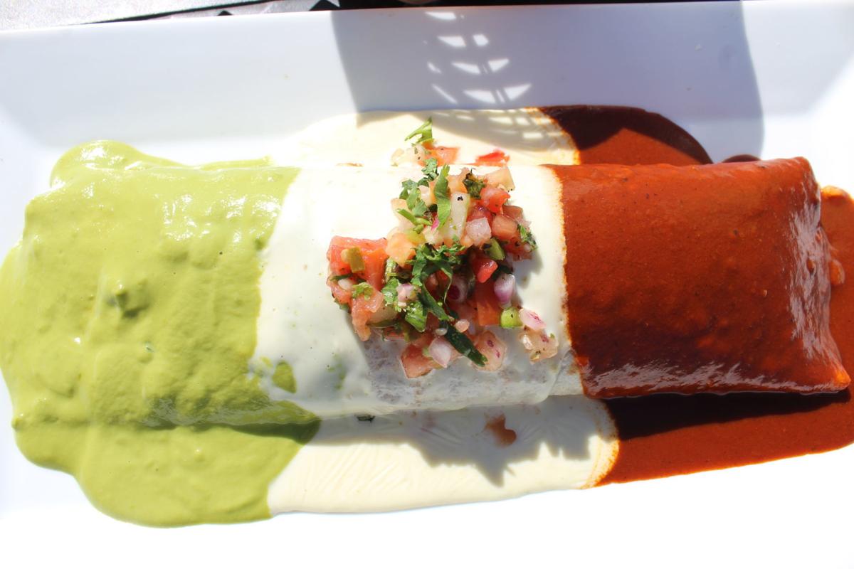 12-inch Burrito Bandera, stuffed with ground beef, beans, rice and cheese and topped with Verde sauce, cheese sauce and red sauce with salsa garnish on top. .JPG