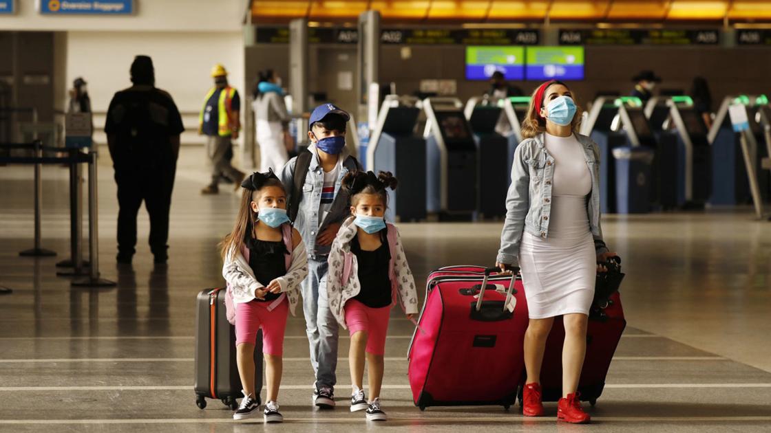 Yadira Barajas walks with her children Owen Vargas, 11, and 6-year-old twins Madison and Madelyn Contreras, as they prepare for a flight to Mexico at 