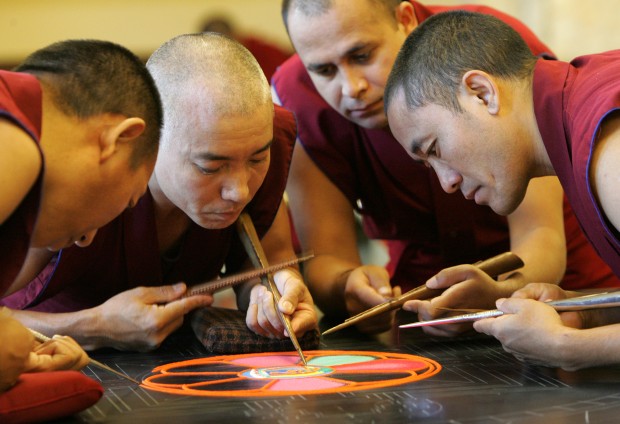 Buddhist monks create a sand mandala