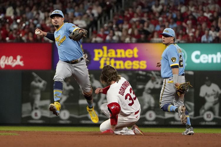 Milwaukee Brewers' Keston Hiura, center, celebrates his run scored against  the Arizona Diamondbacks with teammates Christian Yelich, right, and Brent  Suter, left, during the eighth inning of a baseball game Sunday, July