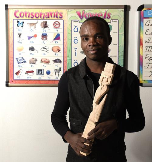 Amisi Juma Holds Carving Above All Else