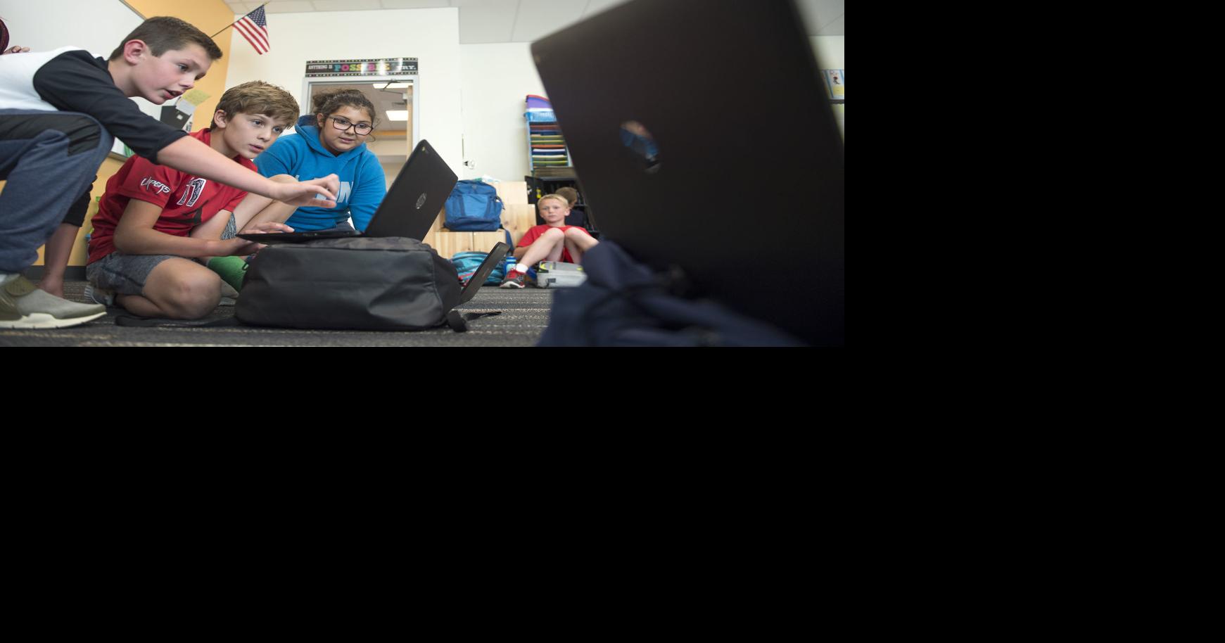Elementary students using laptops, robots and 3D printer in new coding club