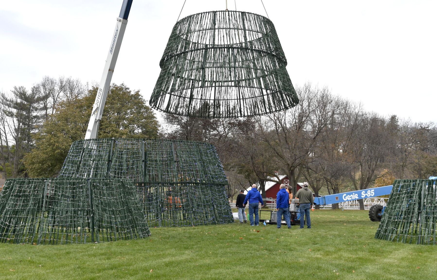 Volunteers, and a crane, raise Kiwanis Holiday Lights tree Photos