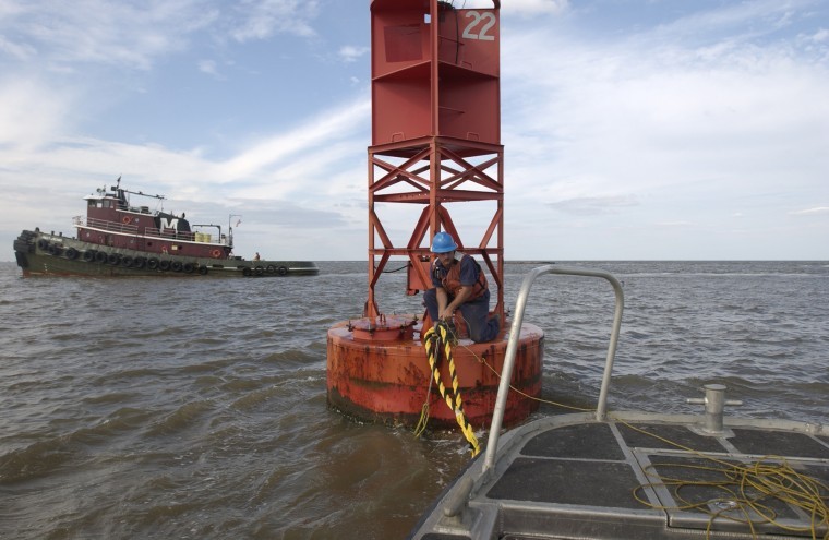 A U.S. Coast Guard ties a line to tow a buoy