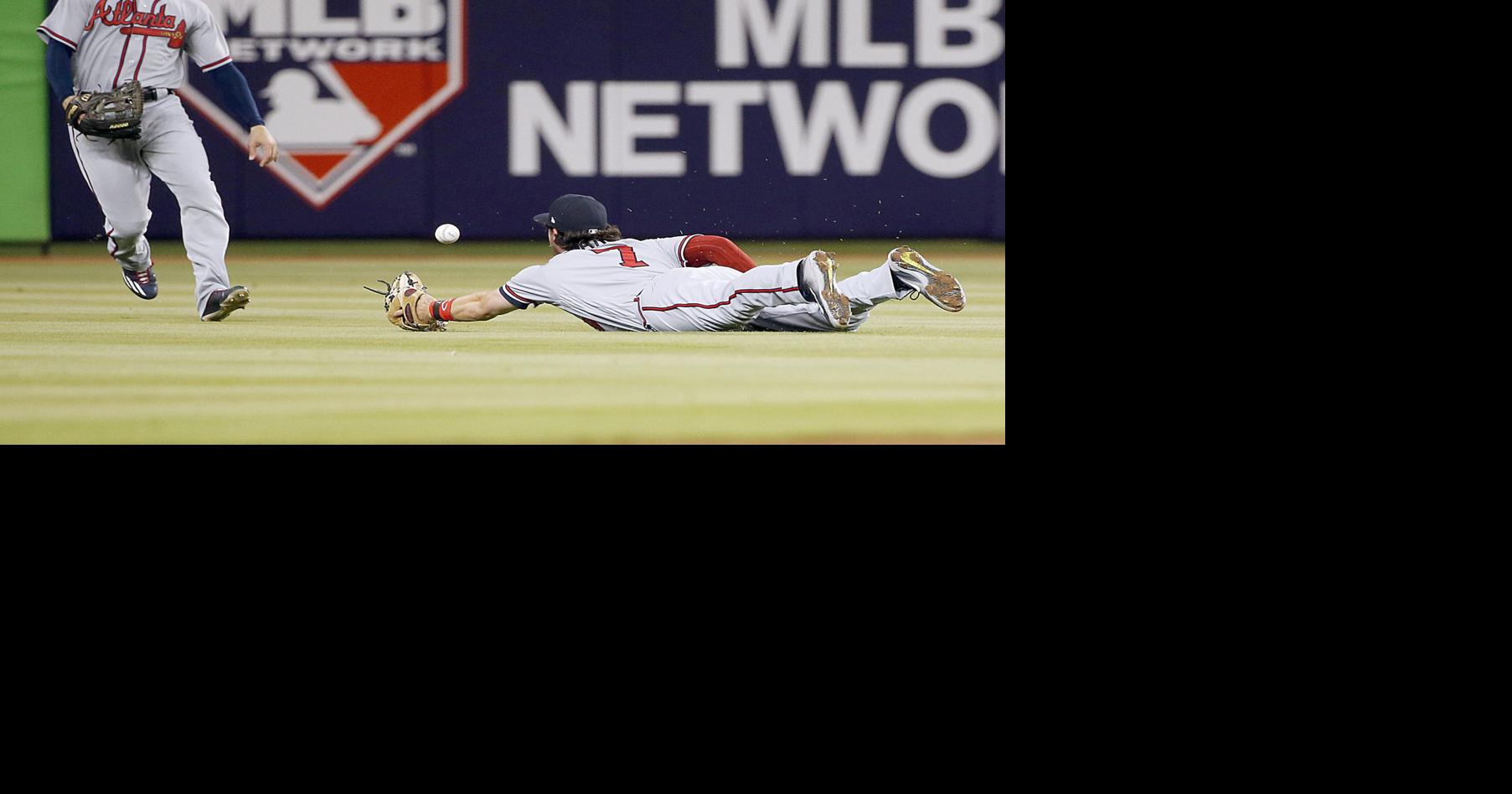 Cat takes cover as Ozuna's 2 HRs help Miami beat Braves, 8-4