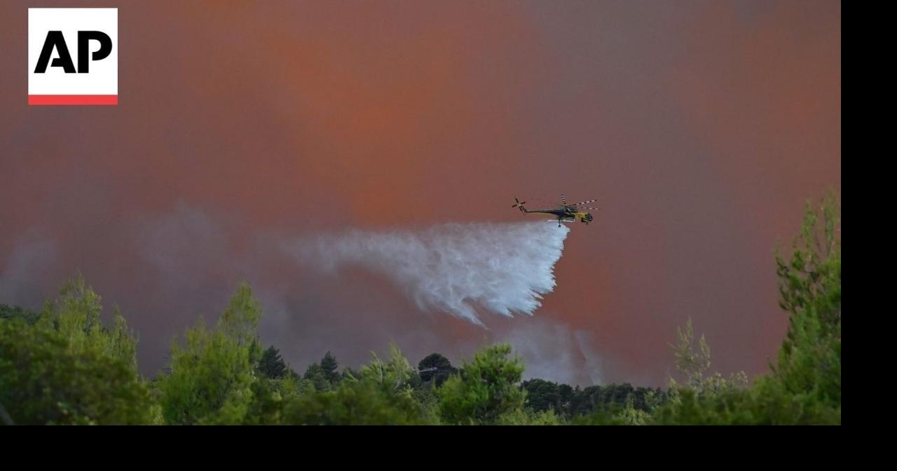 Greece firefighters battle wildfire in seaside community of Porto Germeno
