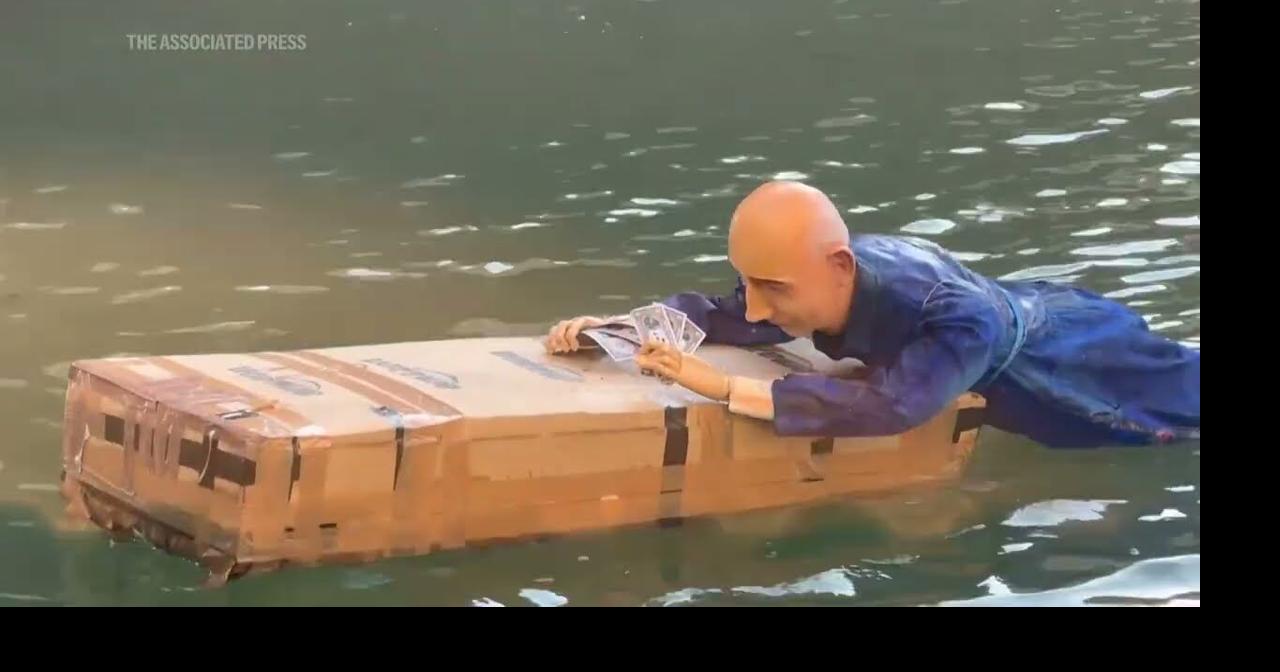 Life-size mannequin of Jeff Bezos lying on a giant Amazon box dropped ...