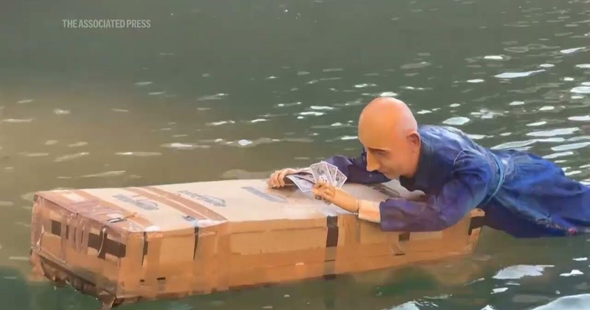 Jeff Bezos Box Life-size mannequin of Jeff Bezos lying on a giant Amazon box dropped ...