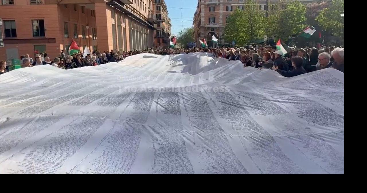 People march in Rome with a shroud bearing the names of the children who have died in Gaza