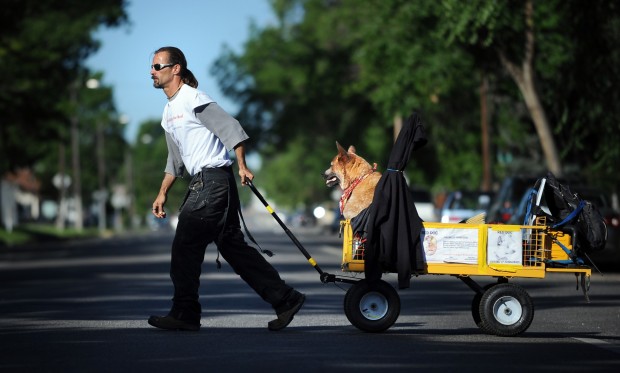 Mike Mallory pulls his dog, Red, on a wagon