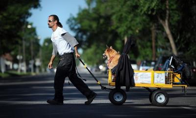 Mike Mallory pulls his dog, Red, on a wagon