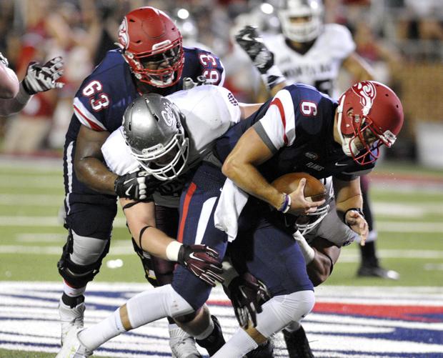 Montana’s Caleb Kidder, center, tackles Liberty quarterback Josh Woodrum while being pressured by Liberty’s Jonathan Burgess during the Grizzlies’ 31-21 loss on Saturday at Williams Stadium in Lynchburg, Va. (Tom Bauer/The Missoulian)