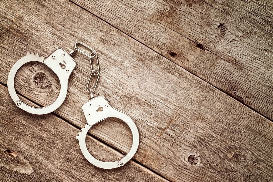 Closed handcuffs on wooden background