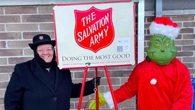 Capt. Wendy Parsons and Shane Walker as the Grinch ring the bell