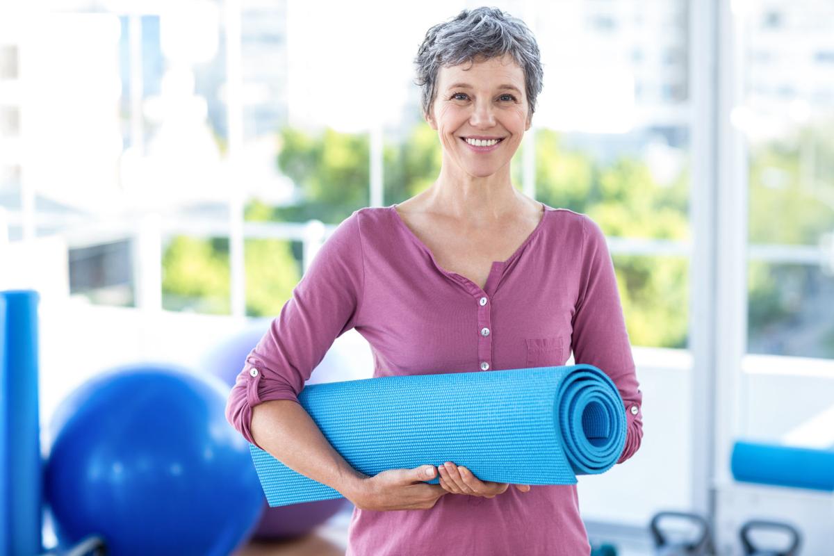 Portrait of mature woman with yoga mat