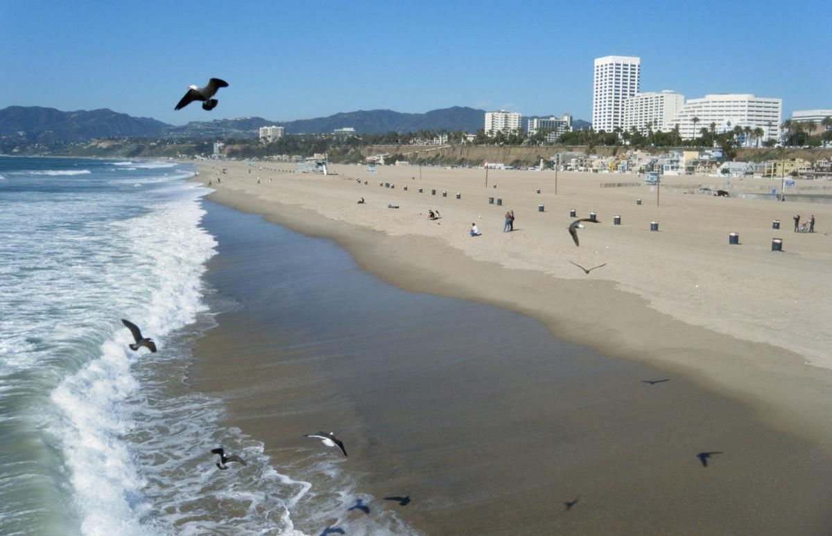Even on a cool February afternoon, the beach in Santa Monica, CA, attracts a few sun-seekers in this file photo. Santa Monica has become more posh in recent years, leading to price increases at hotels in town.