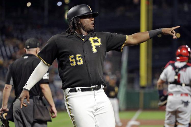 Pittsburgh Pirates' Adam Frazier, right, stands on third base next