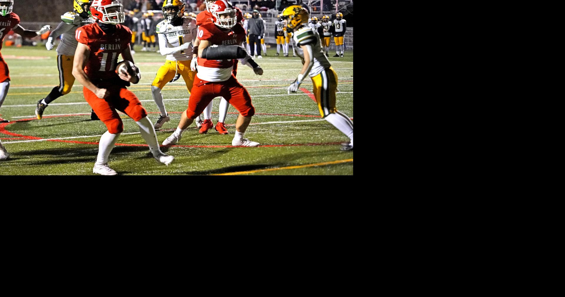 Berlin quarterback Cody Puzio (11) flexes after scoring one of his two first-half rushing touchdowns in Berlin’s 49-7 rout over Holy Cross in the Class M semifinals. 