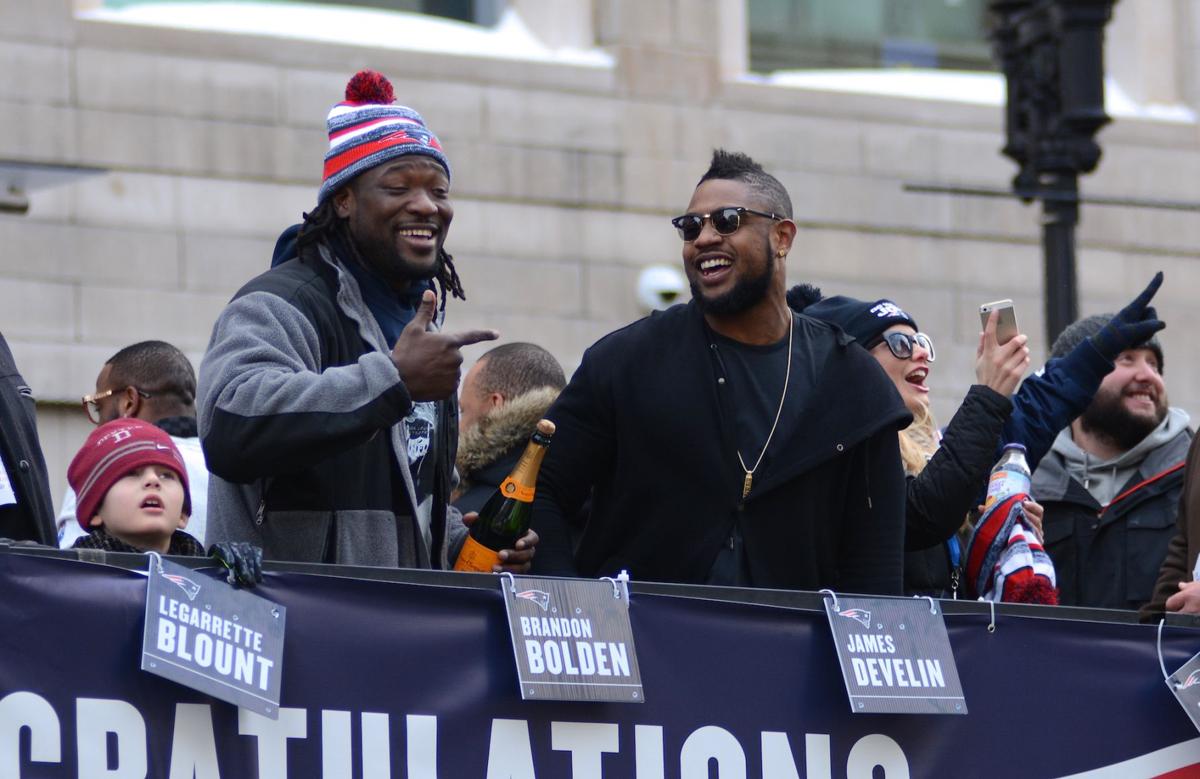 Patriots Running Backs LaGarrette Blount, left, and Stevan Ridley, right, celebrate with a bottle of champagne during the team's celebratory parade.